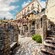 People standing on the balcony and looking down at a walkway and staircase made from ancient stones